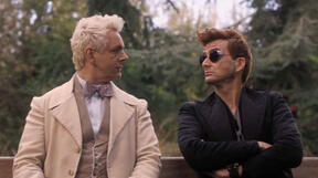 Aziraphale and Crowley from Good Omens sitting on a bench together, talking. Crowley has his arms crossed