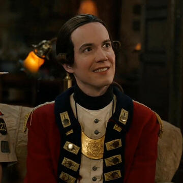 Nigel Chessum from Ghosts looking up and smiling at someone